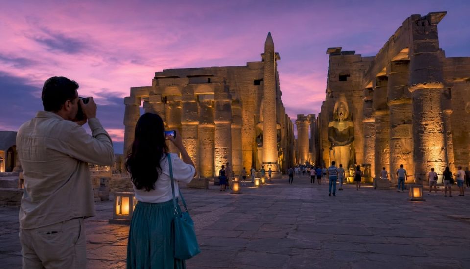 Couple visiting Luxor Temple at dusk with lighting