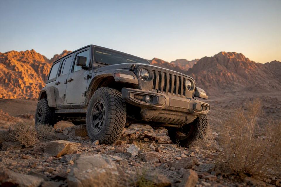 4x4 jeep parked in desert near mountains